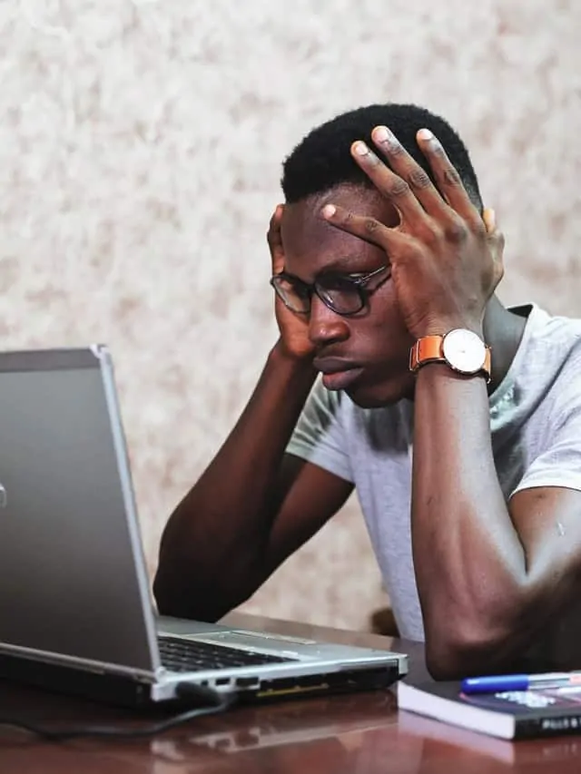 man with stress holds his head